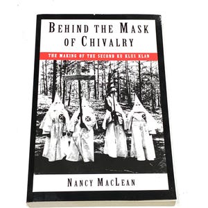 May include: A book titled "Behind the Mask of Chivalry" by Nancy MacLean. The cover features a black and white image of figures in white robes and pointed hoods, with a cross in the background. The subtitle reads "The Making of the Second Ku Klux Klan."