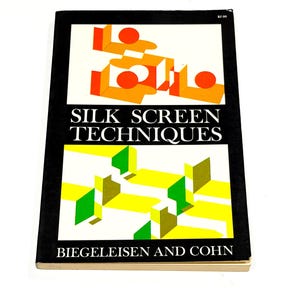 May include: A softcover book titled Silk Screen Techniques by Biegeleisen and Cohn. The black cover features two rectangular graphic panels: the top with orange circles and shapes, the bottom with yellow and green geometric forms on white.