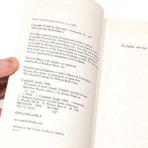 a hand holding a book open to a page