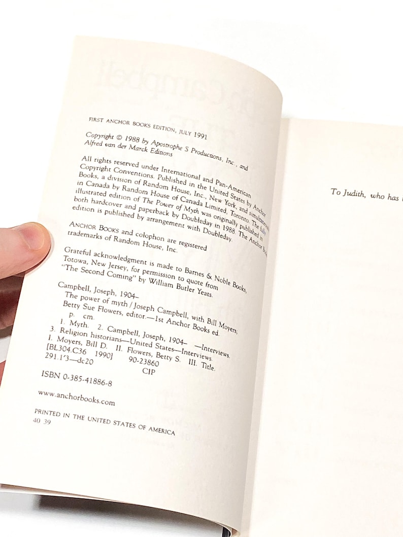 a hand holding a book open to a page