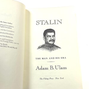 Puede incluir: Un libro abierto con el t&iacute;tulo "STALIN" y un retrato de Joseph Stalin. El libro se titula "THE MAN AND HIS ERA" de Adam B. Ulam, publicado por The Viking Press, Nueva York.