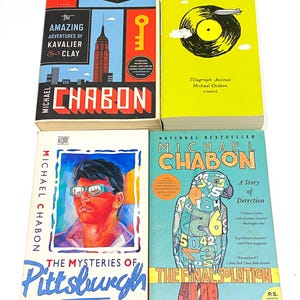 May include: Four books by Michael Chabon are displayed. The covers feature various designs, including a cityscape, a record, a portrait, and a parrot with numbers. Titles include "The Amazing Adventures of Kavalier & Clay" and "The Final Solution".