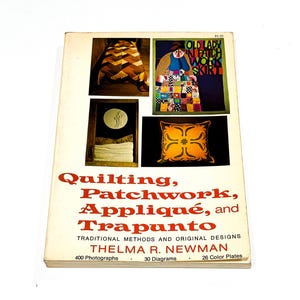 May include: A vintage book titled "Quilting, Patchwork, Appliqué, and Trapunto" by Thelma R. Newman. The cover features images of quilts and patchwork designs. The book contains 400 photographs, 30 diagrams, and 26 color plates.