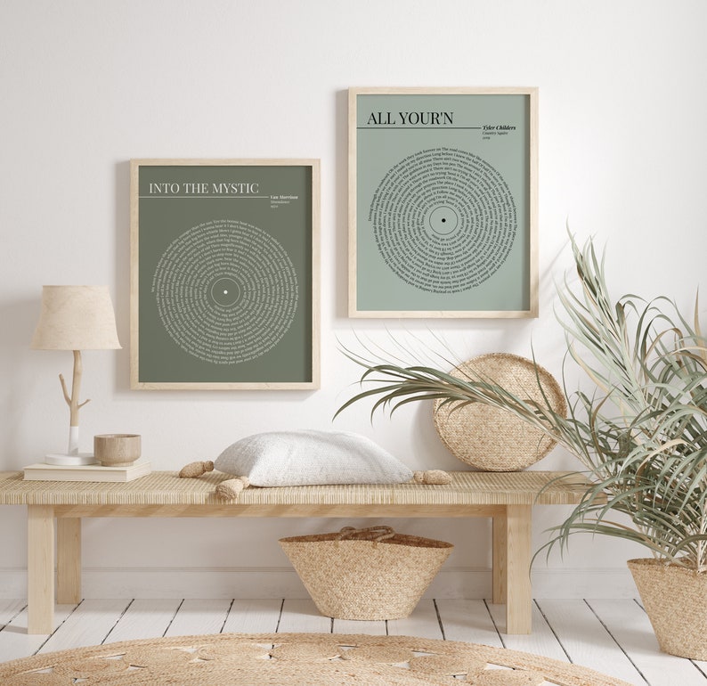 K&ouml;nnte beinhalten: Zwei gerahmte Kunstdrucke mit Songtexten in einem kreisf&ouml;rmigen Design. Die Drucke haben einen salbeigr&uuml;nen Hintergrund und sind in hellen Holzrahmen. Einer der Drucke lautet "Into the Mystic", der andere "All Your'n". Sie werden auf einer hellen Holzbank ausgestellt.
