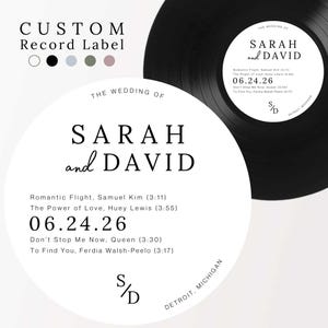 May include: A custom circular record label featuring the text THE WEDDING OF SARAH and DAVID, a list of four songs with artists and durations, the date 06.24.26, and the initials S/D. The label is shown on a black vinyl record and as a standalone white circle.