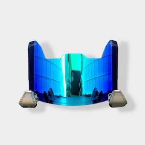May include: A blue and silver football helmet visor with a futuristic design. The visor has a reflective surface with a blue and green gradient. The visor has two silver clips on the bottom.