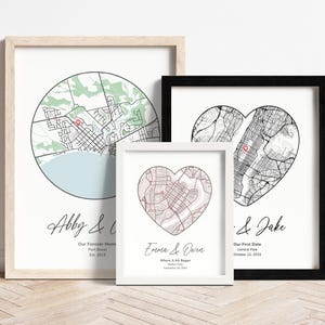 Op de afbeelding: Drie ingelijste prints met zwart-witte stadskaarten in de vorm van een hart en een cirkel. De tekst op de prints luidt "Abby &", "Emara & Owen" en "& Jake".