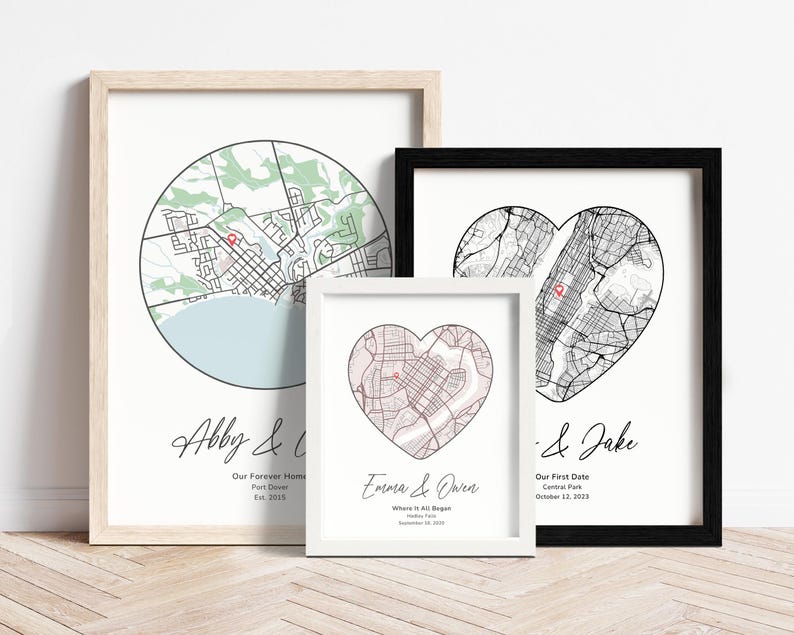 Op de afbeelding: Drie ingelijste prints met zwart-witte stadskaarten in de vorm van een hart en een cirkel. De tekst op de prints luidt "Abby &", "Emara & Owen" en "& Jake".