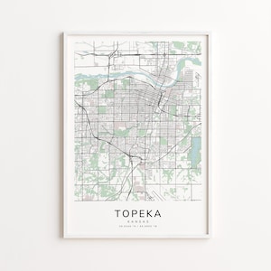 Peut inclure: Impression encadrée d'une carte de Topeka, Kansas, avec un quadrillage de rues noir et blanc détaillé avec des accents verts et bleus. Le nom de la ville et les coordonnées sont imprimés en bas. La carte est encadrée dans un cadre blanc.