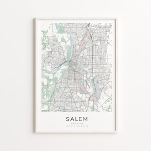 May include: A framed map print of Salem, Oregon, featuring a detailed black and white street grid with light green and blue water features. The city name is centered at the bottom, with coordinates below.