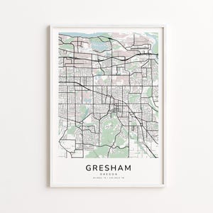 May include: A framed map print of Gresham, Oregon, featuring a detailed street grid in black and white. The map includes green areas representing parks and waterways. The city name and coordinates are printed at the bottom.