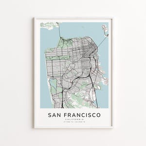 May include: A framed print featuring a detailed map of San Francisco, California. The map is in black and white, set against a light blue background. The city's name is printed in a clean, modern font at the bottom.