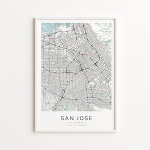 May include: A framed map print of San Jose, California, featuring a detailed street grid and surrounding geographical features. The map is in black and white with light green and blue accents, and the city name is printed in a clean, modern font.