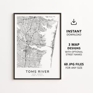 May include: A black and white map print of Toms River, New Jersey, featuring a detailed street grid and water bodies. The text at the bottom reads TOMS RIVER NEW JERSEY 39.9509 N / 74.1858 W. The design is framed in a thin black border on a white background.