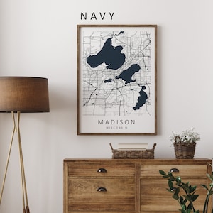 Mockup map print example. Map is displayed in a wooden frame on a white wall. The Interior could be described as rustic or farmhouse chic.
The example picture is in portrait. The displayed map is in a navy color palette with black roads.