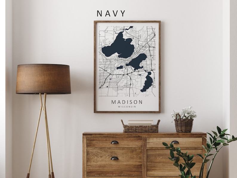 Mockup map print example. Map is displayed in a wooden frame on a white wall. The Interior could be described as rustic or farmhouse chic.
The example picture is in portrait. The displayed map is in a navy color palette with black roads.