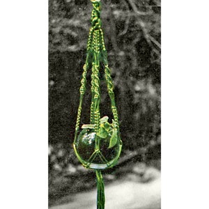 May include: A green macrame plant hanger with a glass globe for a pot. The hanger is hanging from a ceiling hook and has a long tassel at the bottom.
