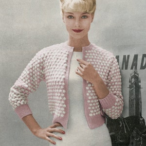 May include: A pink and white knitted cardigan with a textured design. The cardigan has a button-up front and long sleeves.