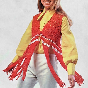 May include: A red crocheted vest with white beads and long fringe. The vest is worn over a yellow button-down shirt and white trousers.
