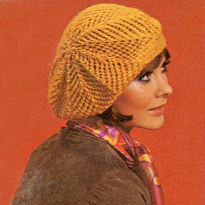 May include: A woman wearing a yellow knitted beret with a brown jacket and a colourful scarf.