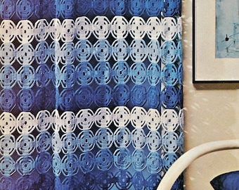 May include: A blue and white crocheted curtain with a repeating circular pattern. The curtain is a gradient of blues, with white accents. The curtain is hanging in front of a window, with a painting and a white chair visible.