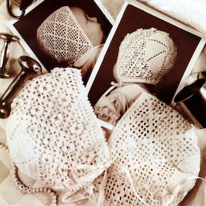 May include: Cream-coloured, crocheted baby bonnets with delicate floral and openwork patterns. The image includes two bonnets, a rattle, and two vintage photographs of babies wearing similar bonnets. A beaded necklace spells out "BABY".