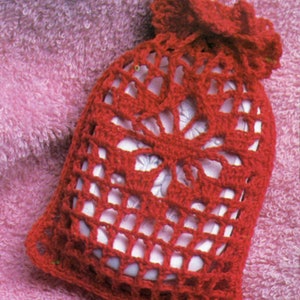 May include: Red crocheted soap bag with a floral design. The bag is made with a delicate openwork pattern and has a drawstring closure.