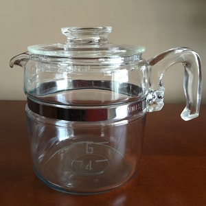 May include: A clear glass percolator coffee pot with a stainless steel band around the bottom. The pot has a glass lid and a glass handle.