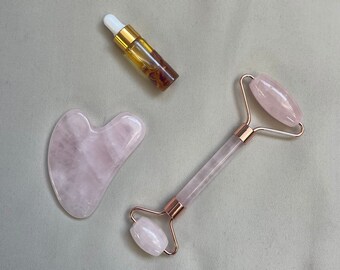 May include: A set of rose quartz beauty tools including a roller and a gua sha tool, along with a small bottle of facial oil.