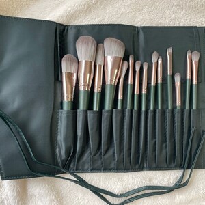 Pu&ograve; includere: Un rotolo nero per pennelli da trucco con 18 pennelli. I pennelli hanno manici verdi e ferrule in oro rosa. Il rotolo ha una chiusura con cordoncino nero.