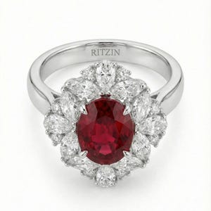 Peut inclure: Bague en platine ornée d'un rubis ovale central, entouré d'un halo de diamants en forme de poire. La bague a un anneau poli et le nom de la marque "RITZIN" est gravé à l'intérieur.