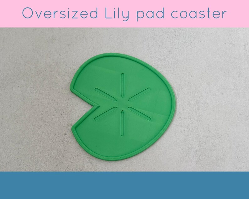May include: A green, oversized lily pad coaster. The coaster is shaped like a lily pad with a section cut out. The text "Oversized Lily pad coaster" is at the top of the image.