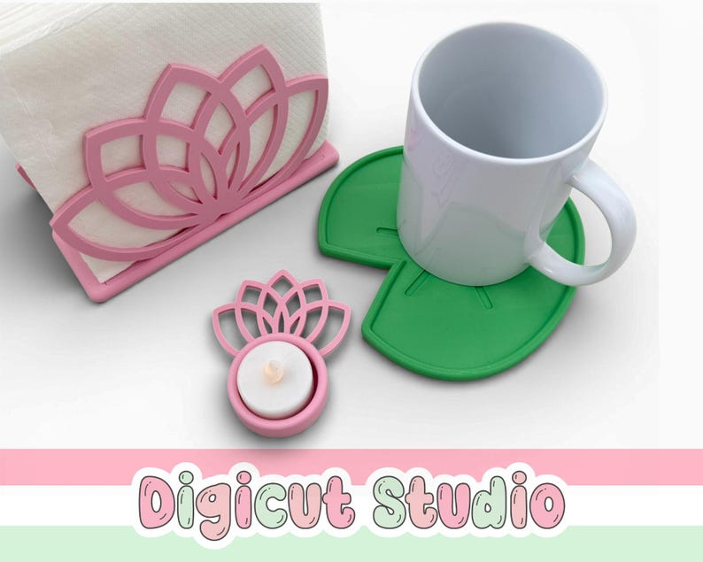 May include: A pink lotus flower-shaped napkin holder, a matching tealight candle holder, and two green lily pad-shaped coasters. A white mug sits on one of the coasters. The text "Digicut Studio" is at the bottom.