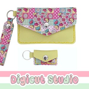 Könnte beinhalten: Ein gelber Kartenhalter im Umschlag-Stil und ein passendes Miniatur-Etui, beide mit einem Patchwork-Muster aus Schmetterlingen, Blumen und Herzen. Jeder Artikel verfügt über einen silbernen Metalldruckknopf und einen silbernen Schlüsselring.