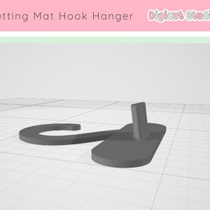 May include: A gray cutting mat hook hanger. The hanger has a curved hook shape connected to a rectangular base with a vertical post. The text "Cutting Mat Hook Hanger" and "Digicut Studio" are at the top.