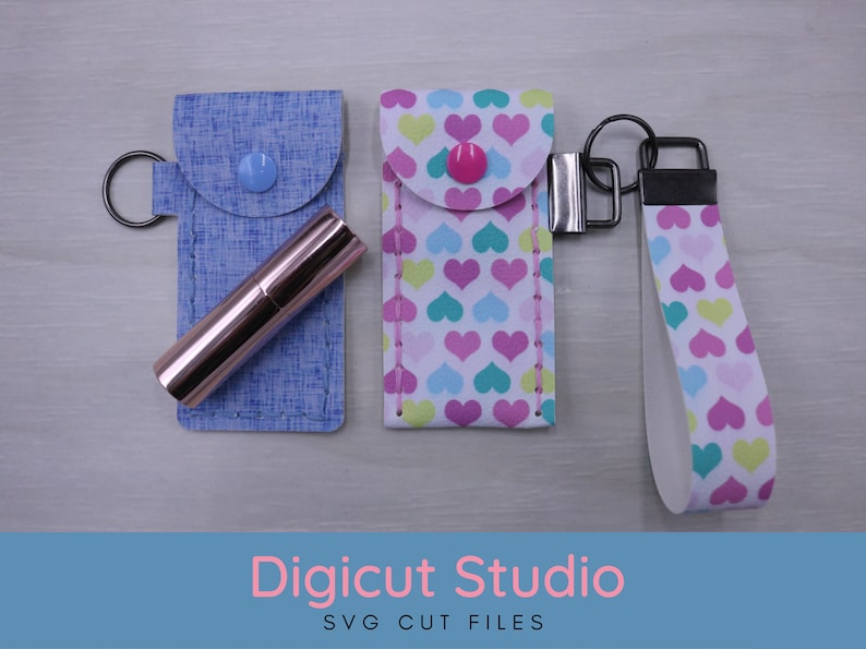 May include: Three keychains with different fabric patterns. The first keychain is blue with a pink lipstick inside. The second keychain is white with pink, blue, and green hearts. The third keychain is white with pink, blue, and green hearts and a black strap. The keychains are labeled "Digicut Studio SVG Cut Files".