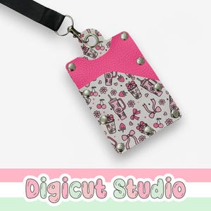 May include: A pink and white lanyard ID holder with a black lanyard. The holder features a pink top and a patterned design with cherries, bows, and drinks. The text "Digicut Studio" is at the bottom.