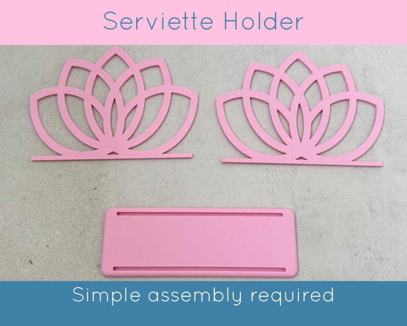 May include: Pink Serviette Holder with a lotus flower design. The holder is made of cut-out shapes and includes the text "Serviette Holder" and "Simple assembly required". The holder is designed to hold napkins.