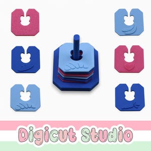 May include: A set of colorful bread bag clips in pink, blue, and light blue, with a central holder. The clips have various embossed designs, including a heart and a bow. The image also includes the text "Digicut Studio".