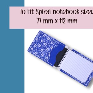 May include: A blue floral spiral notebook cover with a matching pocket. The cover is open, revealing a small spiral notebook with lined pages. The text "To Fit Spiral notebook sized 77 mm x 112 mm" is displayed above the cover.