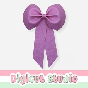 Puede incluir: Un lazo grande de color lavanda con una superficie texturizada. El lazo tiene dos colas largas y puntiagudas y un nudo central. El texto "Digicut Studio" se muestra en la parte inferior de la imagen.