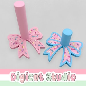 Könnte beinhalten: Ein Set aus drei Keramikbechern mit gesprenkelter, matter Oberfläche. Jeder Becher hat eine andere Farbe: hellblau, cremefarben und grau. Die Becher haben ein schlichtes, modernes Design und einen bequemen Griff.