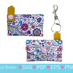 May include: Two small, floral-patterned cardholders with a yellow leather tab and pink snap closure. One cardholder has a silver keychain attached. The floral pattern includes pink, blue, and purple flowers on a white background. The text "Digicut Studio SVG PDF EPS PNG" is at the bottom.