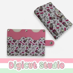 May include: Two cardholders with a white background. The cardholders are decorated with a pattern of cherries, bows, and drinks. One cardholder is open, displaying a pink interior. The other is closed with silver snap closures. The text "Digicut Studio" is at the bottom.