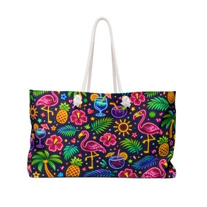 Peut inclure: Grand sac fourre-tout avec un motif tropical néon vibrant. Le design présente des flamants roses, des cocktails, des ananas, des fleurs d'hibiscus, des palmiers et des étoiles sur fond bleu foncé. Le sac a des poignées en corde blanche.