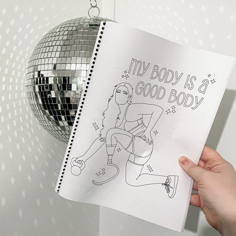 Op de afbeelding: Een zwart-witte kleurplaat met een vrouw die oefent met een gewicht. De tekst op de pagina luidt "My body is a good body."