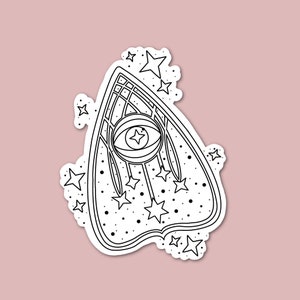 Puede incluir: Una ilustraci&oacute;n en blanco y negro de una planchette con un solo ojo y estrellas. La planchette tiene forma de coraz&oacute;n con una parte superior puntiaguda y una parte inferior redondeada. El ojo est&aacute; en el centro de la planchette y est&aacute; rodeado por un c&iacute;rculo de estrellas.