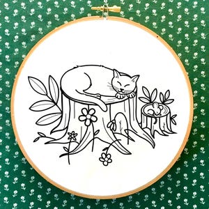 May include: Black and white line drawing of a cat sleeping on a tree stump with a mouse in a smaller stump nearby. The cat is curled up with its paws tucked under its chin. There are flowers and leaves around the stumps.