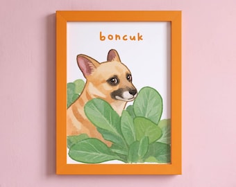 May include: A framed print featuring a tan dog with a dark muzzle peeking out from behind large green leaves. The word "boncuk" is printed in orange letters above the dog's head. The artwork is enclosed in a bright orange rectangular frame.
