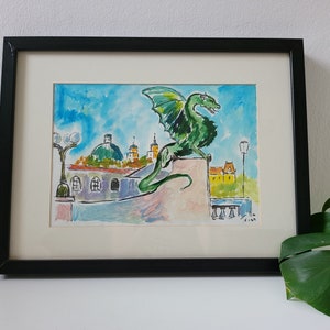 Puede incluir: Una pintura al agua enmarcada de un drag&oacute;n verde encaramado en un edificio con un cielo azul y edificios amarillos en el fondo.